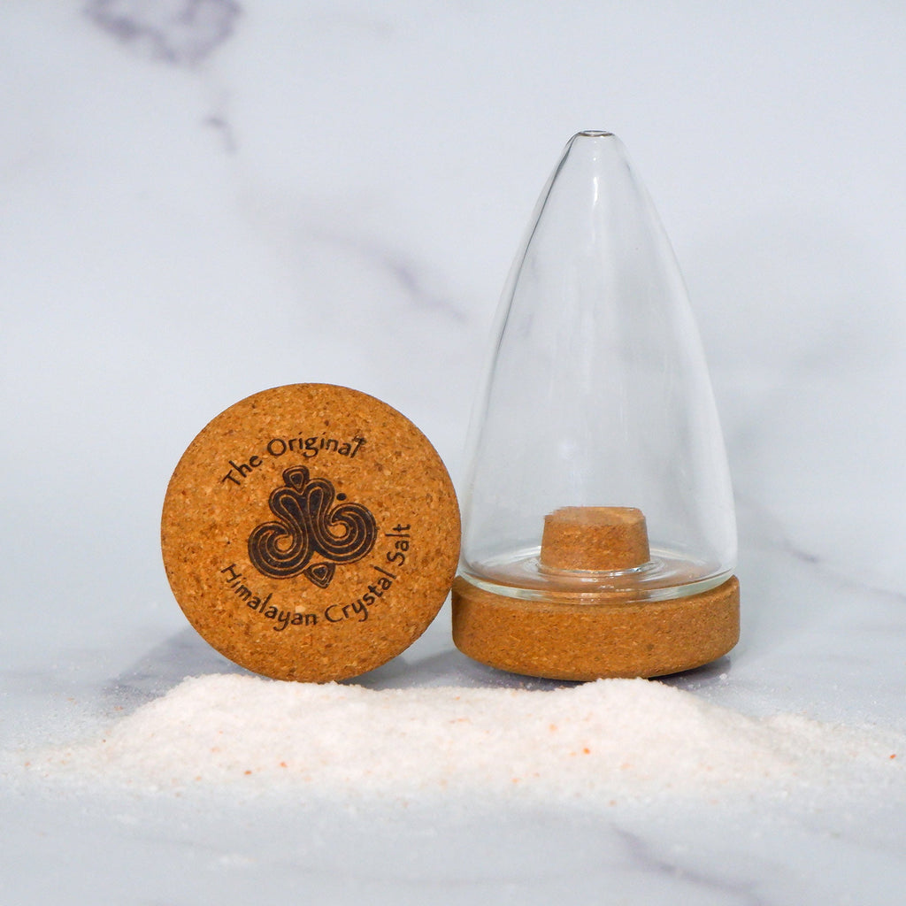 Fine Salt Shaker pointed cylindrical clear glass shaker with cork base with The Original Himalayan Crystal Salt logo, and Himalayan Crystal Salt on gray countertop