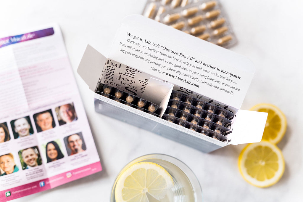 Femmenessence MacaLife<br>For Perimenopause open top product box showing insert and blister packs on counter with lemon slice in glass of water 